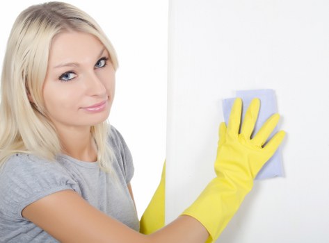 Professional cleaner sanitising desks and shared surfaces in a central London office